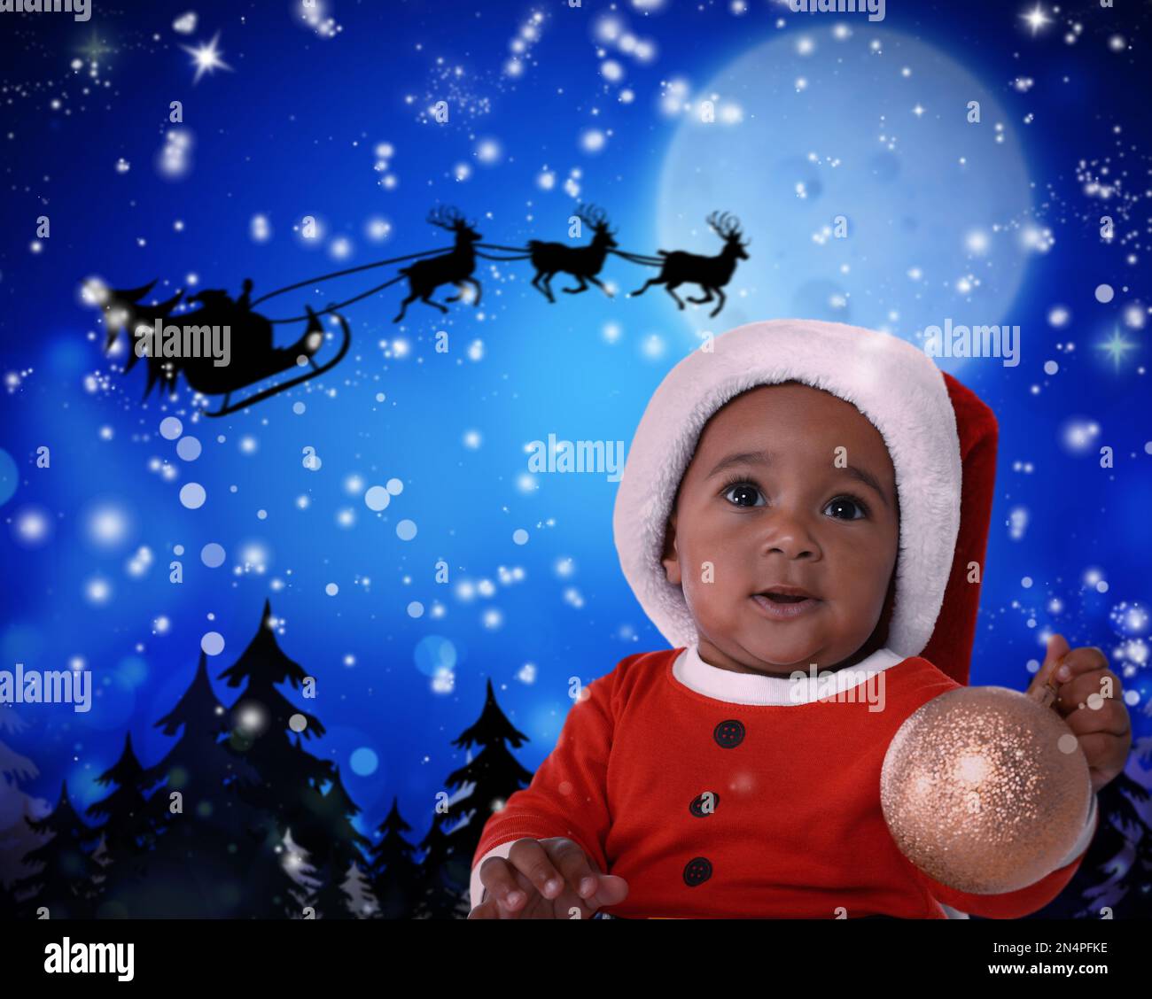 Cute African American bambino e Babbo Natale che vola in sua slitta contro cielo di luna sullo sfondo. Festa di Natale Foto Stock