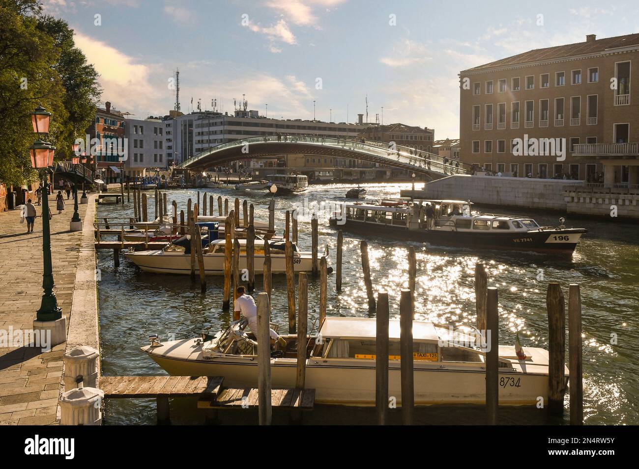 Fondamenta del Monastero sul Canal Grande con Ponte della Costituzione e barche al tramonto, Venezia, Italia Foto Stock