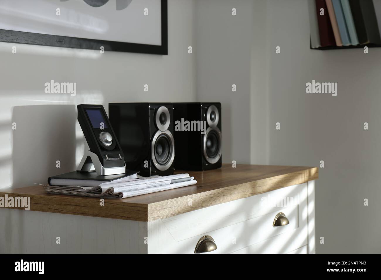 Altoparlanti audio moderni e potenti e telecomando sul cassettiera per interni Foto Stock