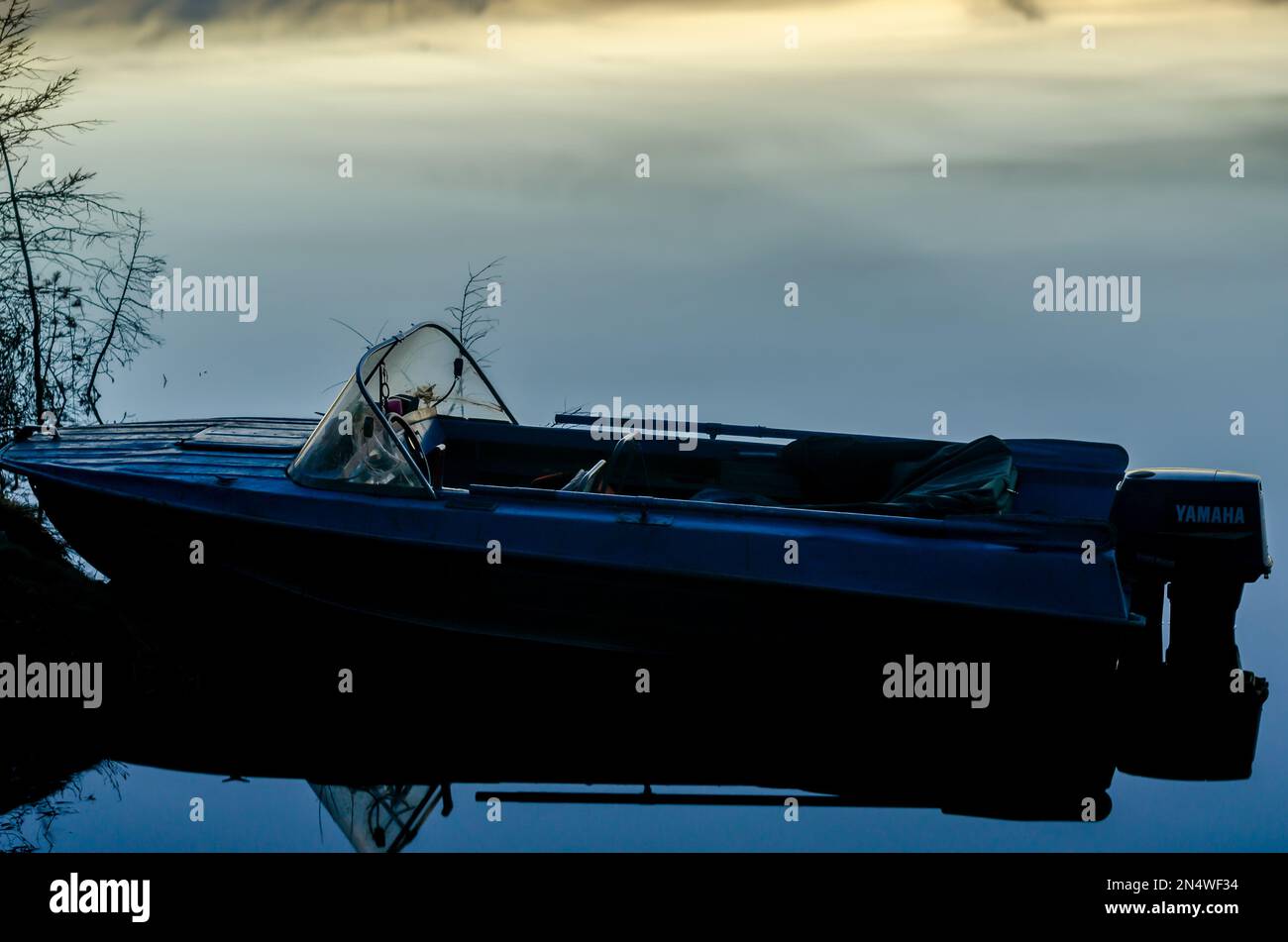 La barca di ferro si trova di notte sul molo, sullo sfondo delle acque calme di Yakutia. Foto Stock