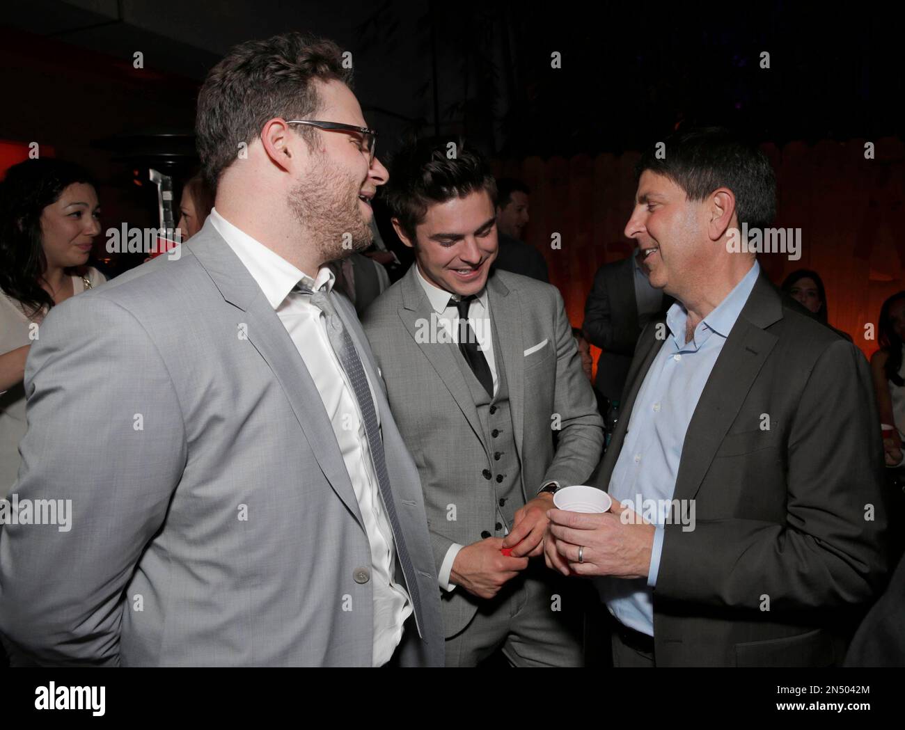 Seth Rogen and from left, Zac Efron and Jeff Shell, chairman, Universal Filmed Entertainment Group speak at the afterparty for the world premiere of "Neighbors" at the Regency Village Theatre on Monday, April 28, 2014, in Los Angeles . (Photo by Todd Williamson/Invision/AP) Foto Stock