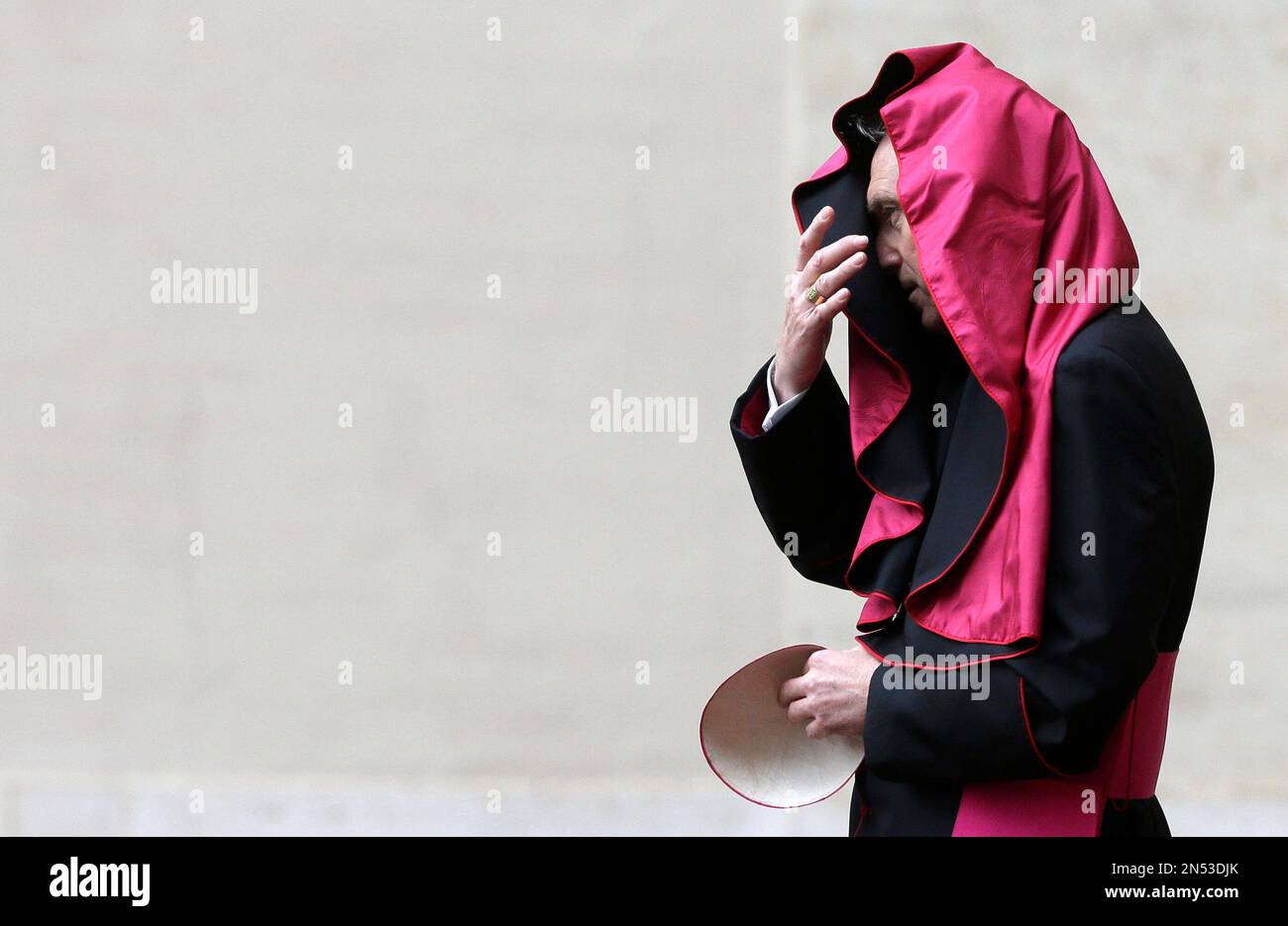 A gust of wind blows the mantle of Archbishop Georg Gaenswein, prefect of the papal household, as he waits for the arrival of President Barack Obama at the Vatican, Thursday, March 27, 2014. (AP Photo/Alessandra Tarantino) Foto Stock