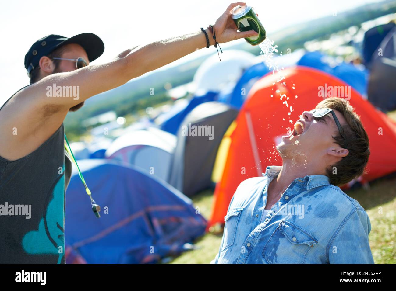 Lasciate che i giochi di bere iniziare. due amici si ubriacano in un festival all'aperto. Foto Stock