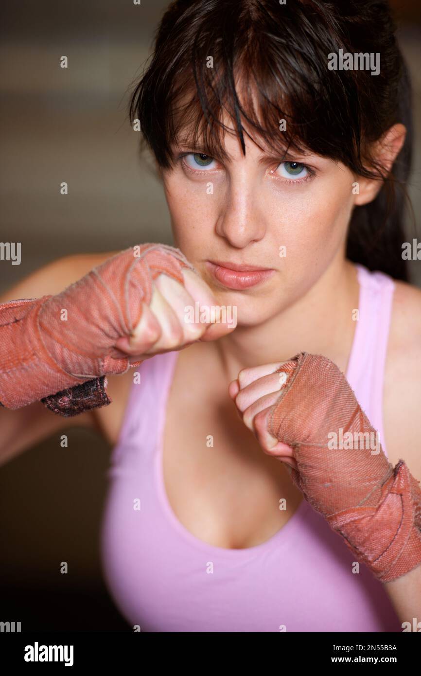 Posizione di attacco. Ritratto di un pugile femminile determinato in piedi pronti a combattere. Foto Stock