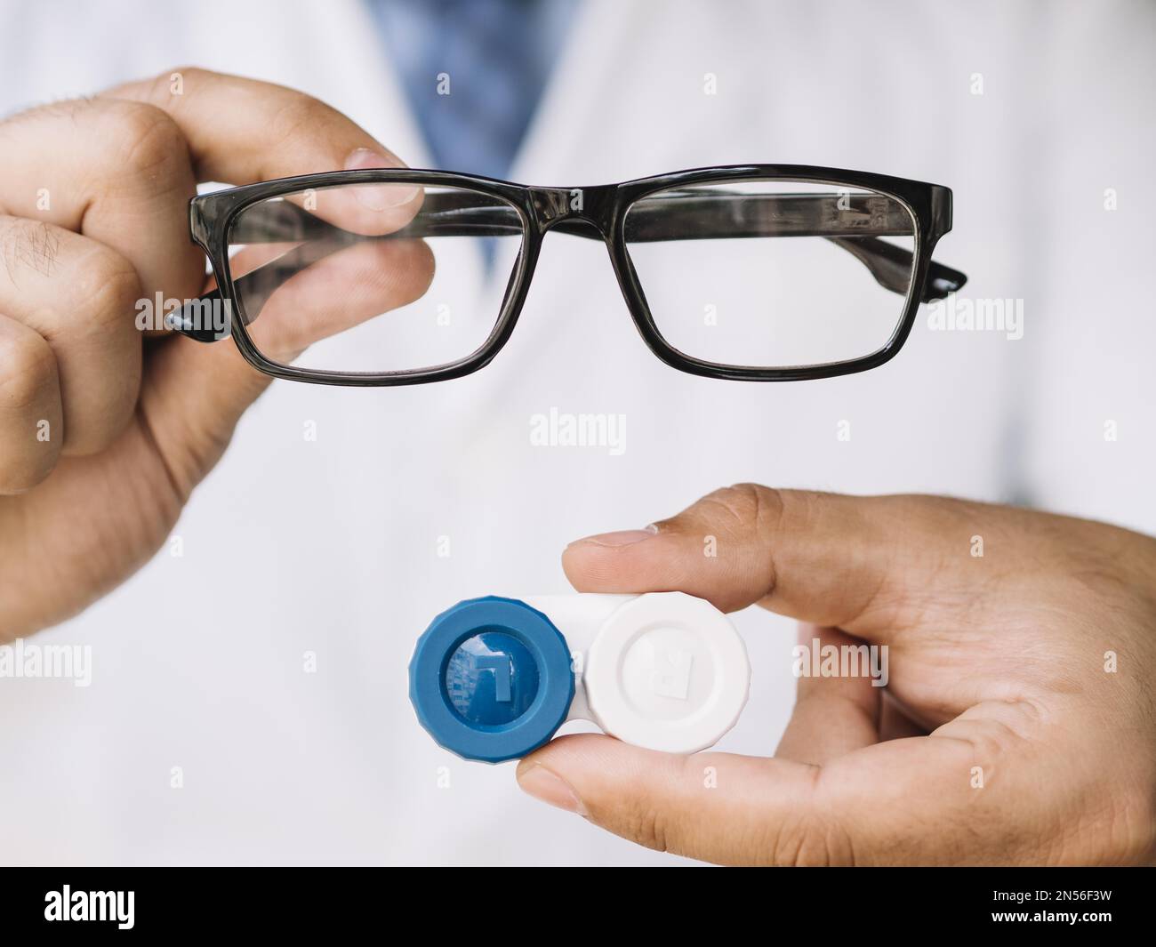 medico maschio che mostra paio di occhiali neri lenti a contatto. Risoluzione e foto di alta qualità Foto Stock