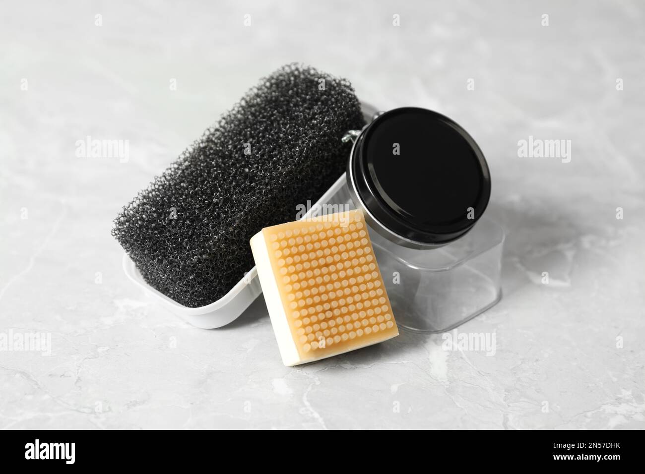 Accessori per la cura delle scarpe su sfondo grigio chiaro Foto Stock