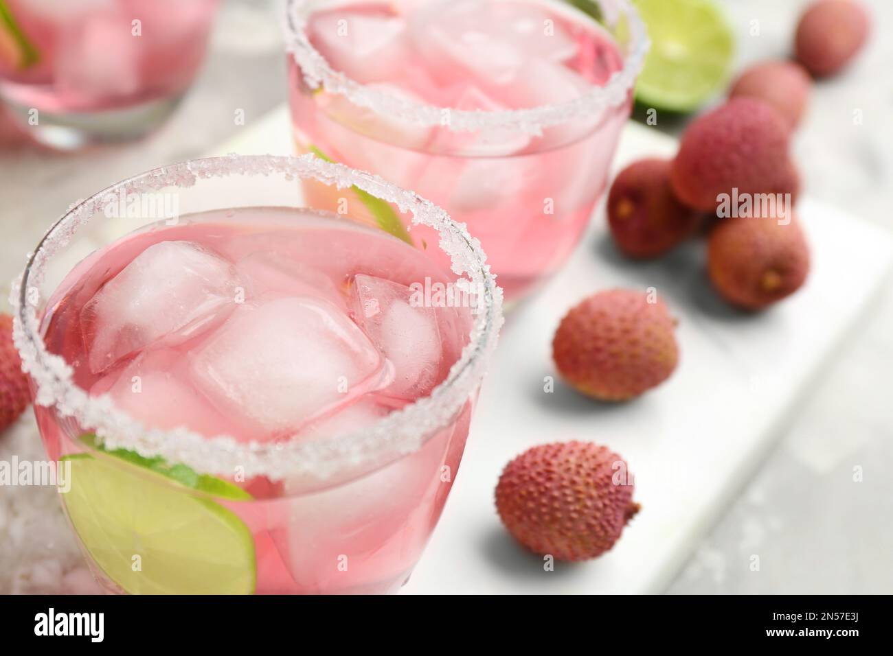 Cocktail di lychee con lime e ghiaccio sul tavolo, primo piano Foto Stock