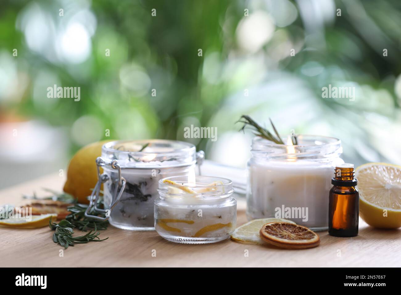 Candele e ingredienti naturali fatti in casa repellenti per zanzare su tavoli di legno all'aperto Foto Stock