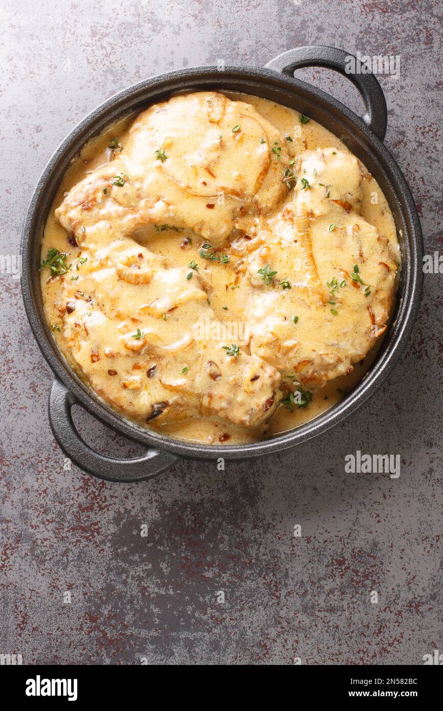 Cibo classico del sud, croccante costolette di maiale soffiato affumicato in un ricco closeup con sugo di cipolla sulla padella sul tavolo. Vista verticale dall'alto Foto Stock