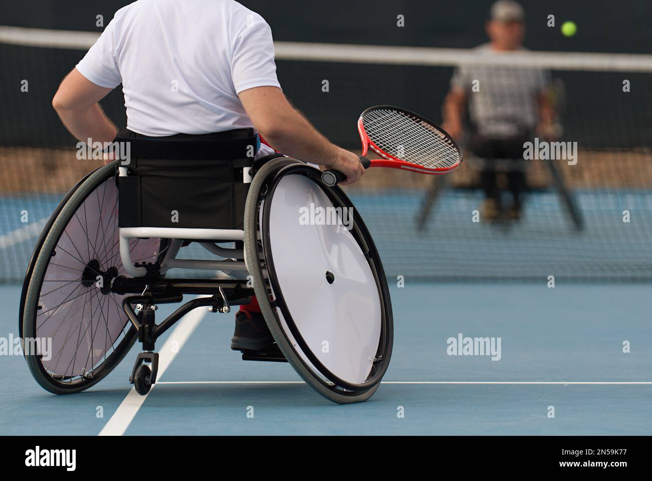 Gli uomini in sedia a rotelle giocano a tennis sul campo da tennis Foto Stock