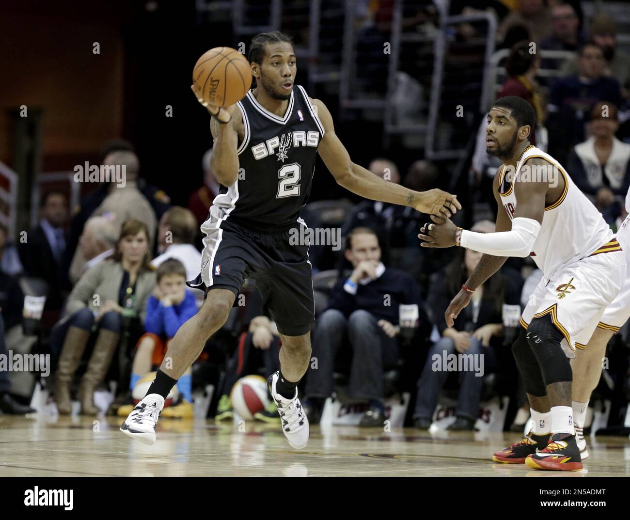 San Antonio Spurs' Kawhi Leonard (2) looks to pass away from Cleveland Cavaliers' Kyrie Irving in an NBA basketball game Tuesday, March 4, 2014, in Cleveland. (AP Photo/Mark Duncan) Foto Stock