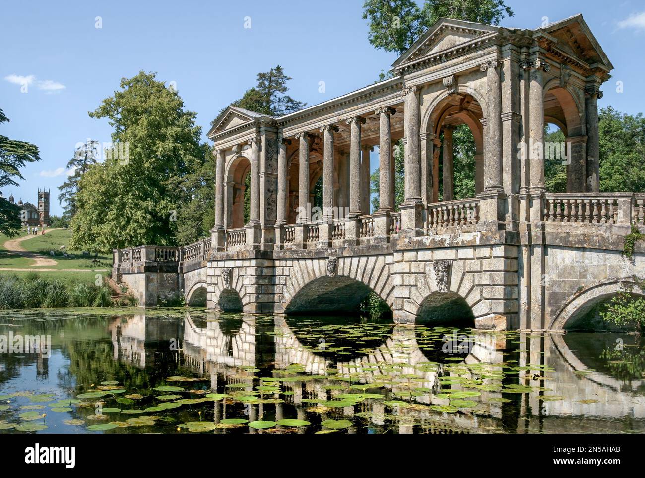 Il Palladian Bridge presso il Stowe Landscape Garden in un giorno d'estate. Bellissimi riflessi in acqua. Foto Stock