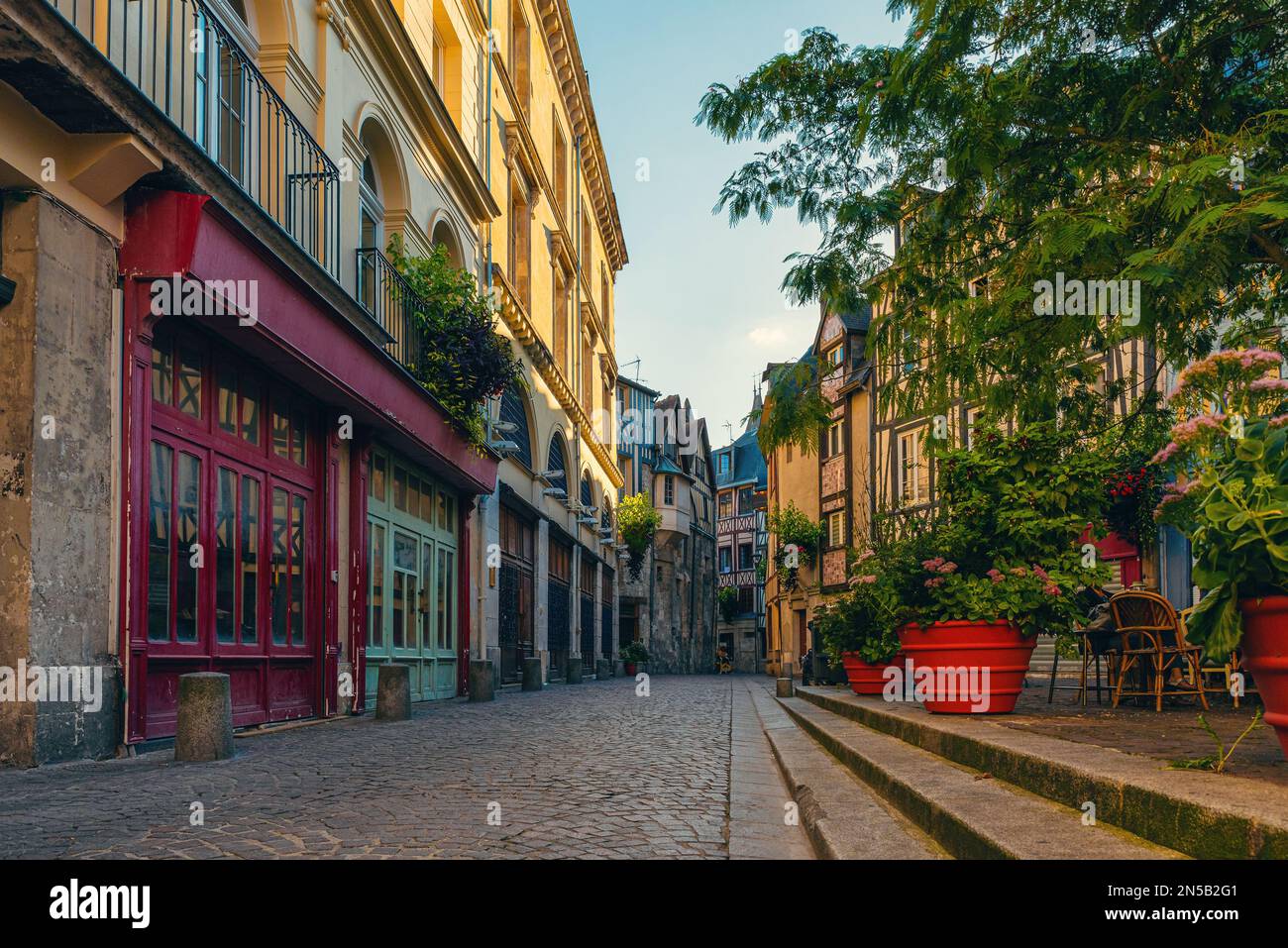 Vecchia strada vuota accogliente con case in legno incorniciato, vasi di fiori e caffè a Rouen, Normandia, Francia. Meta di viaggio popolare Foto Stock