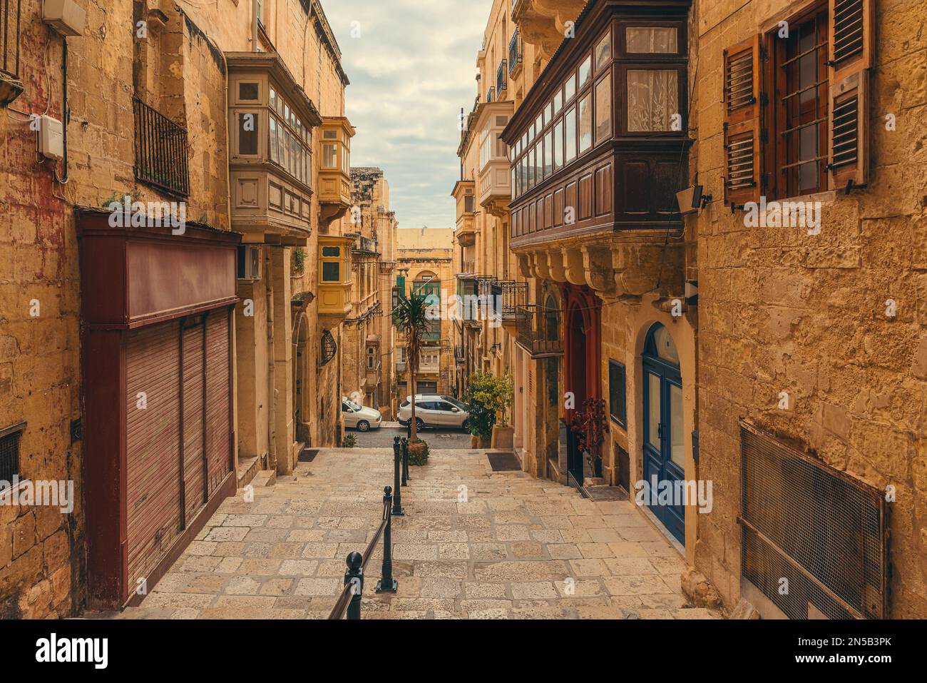 Vecchia strada medievale con balconi sulle case antiche della città di la Valletta, Malta con nessuno. Destinazione di viaggio in Europa Foto Stock