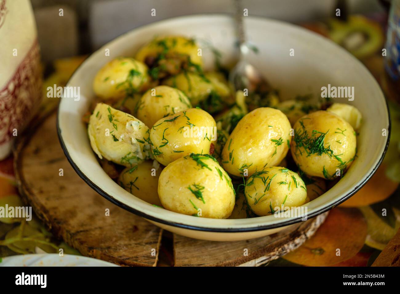 Patate appena sode fresche con aneto fresco su sfondo rustico Foto Stock