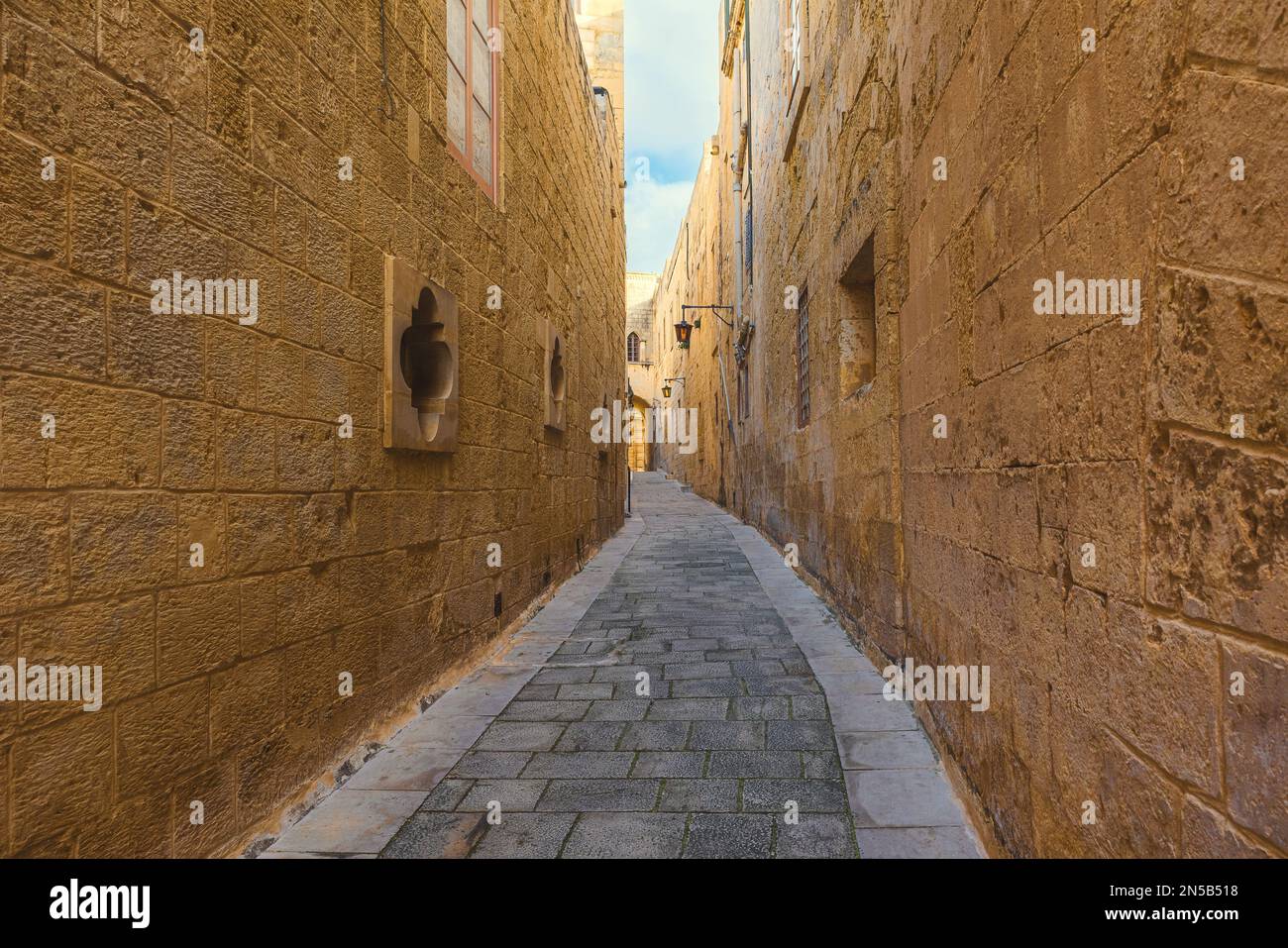 Vuota stradina medievale acciottolata nella città di Mdina, Malta in una giornata di sole. Destinazione di viaggio in Europa Foto Stock