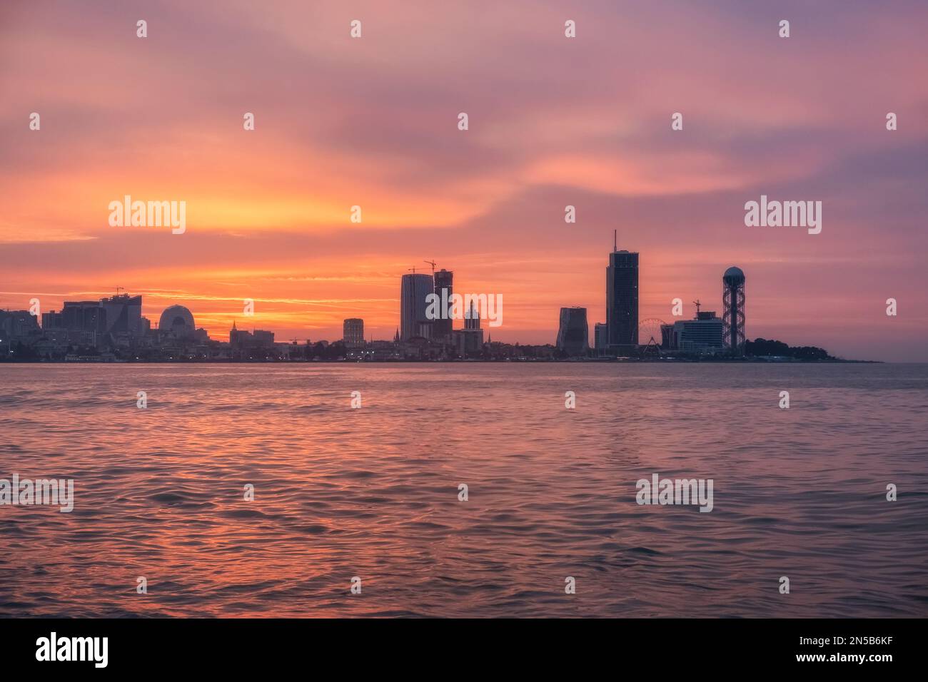 Splendido skyline della città di Batumi e mare con sagome di grattacieli al tramonto ad Adjara, Georgia. Destinazione del viaggio Foto Stock