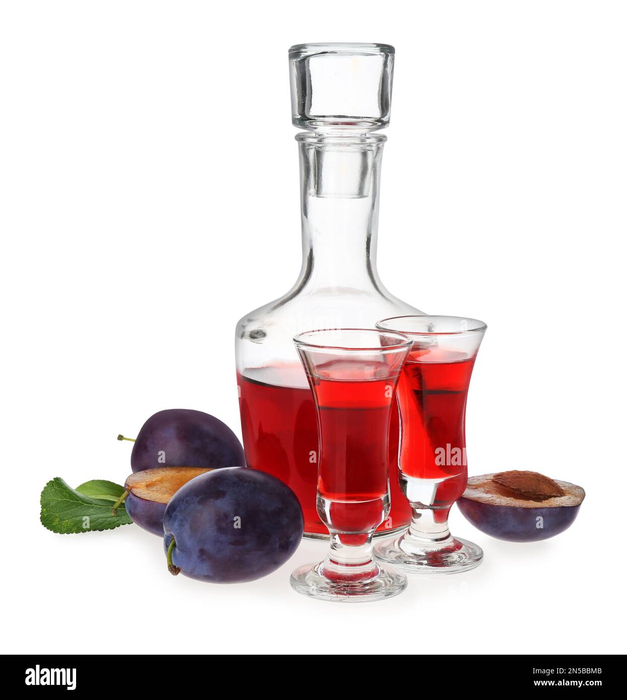 Delizioso liquore di prugne e frutta matura su fondo bianco. Bevanda alcolica forte fatta in casa Foto Stock