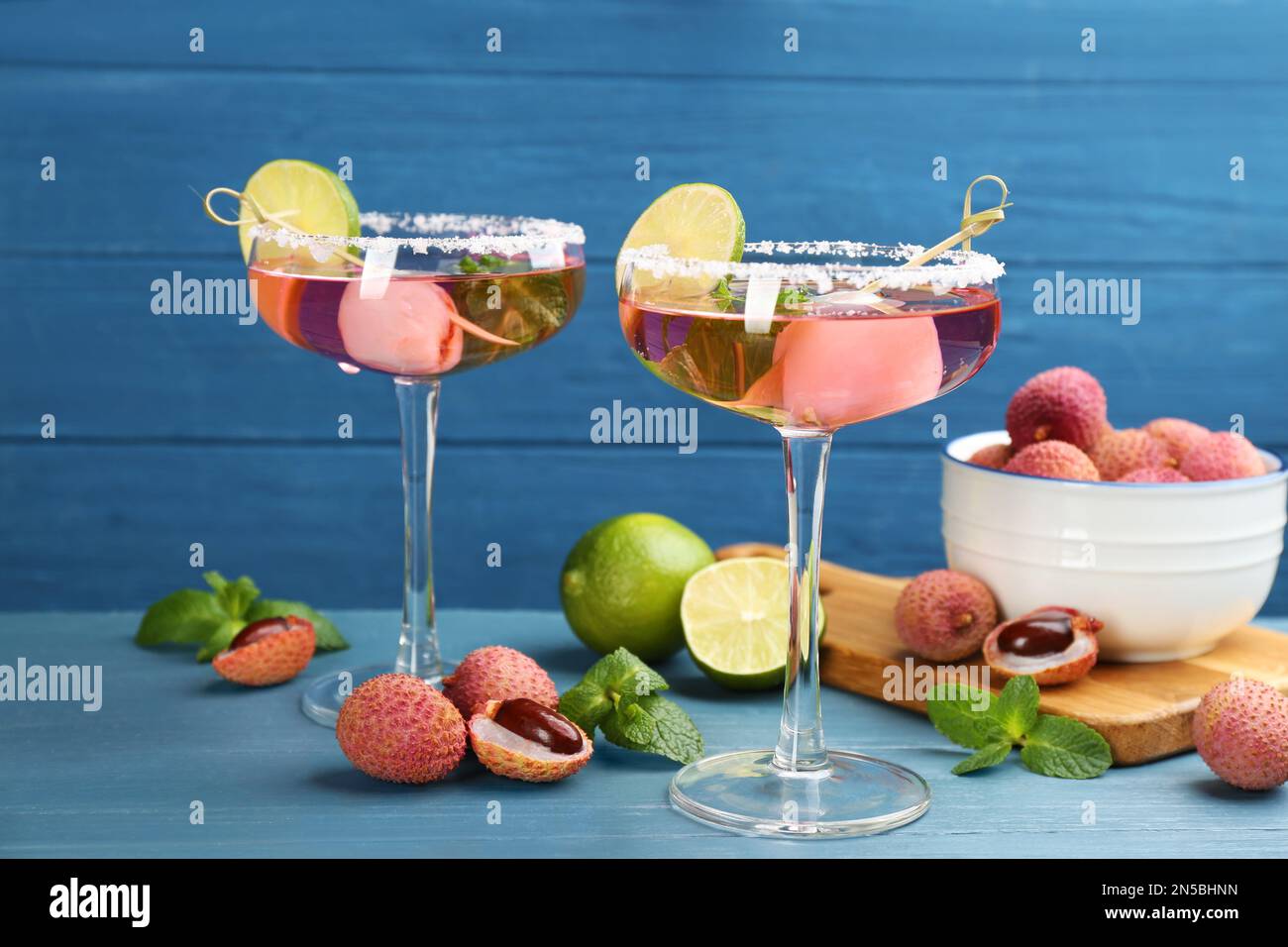 Cocktail di lychee con lime e frutta fresca sul tavolo azzurro Foto Stock
