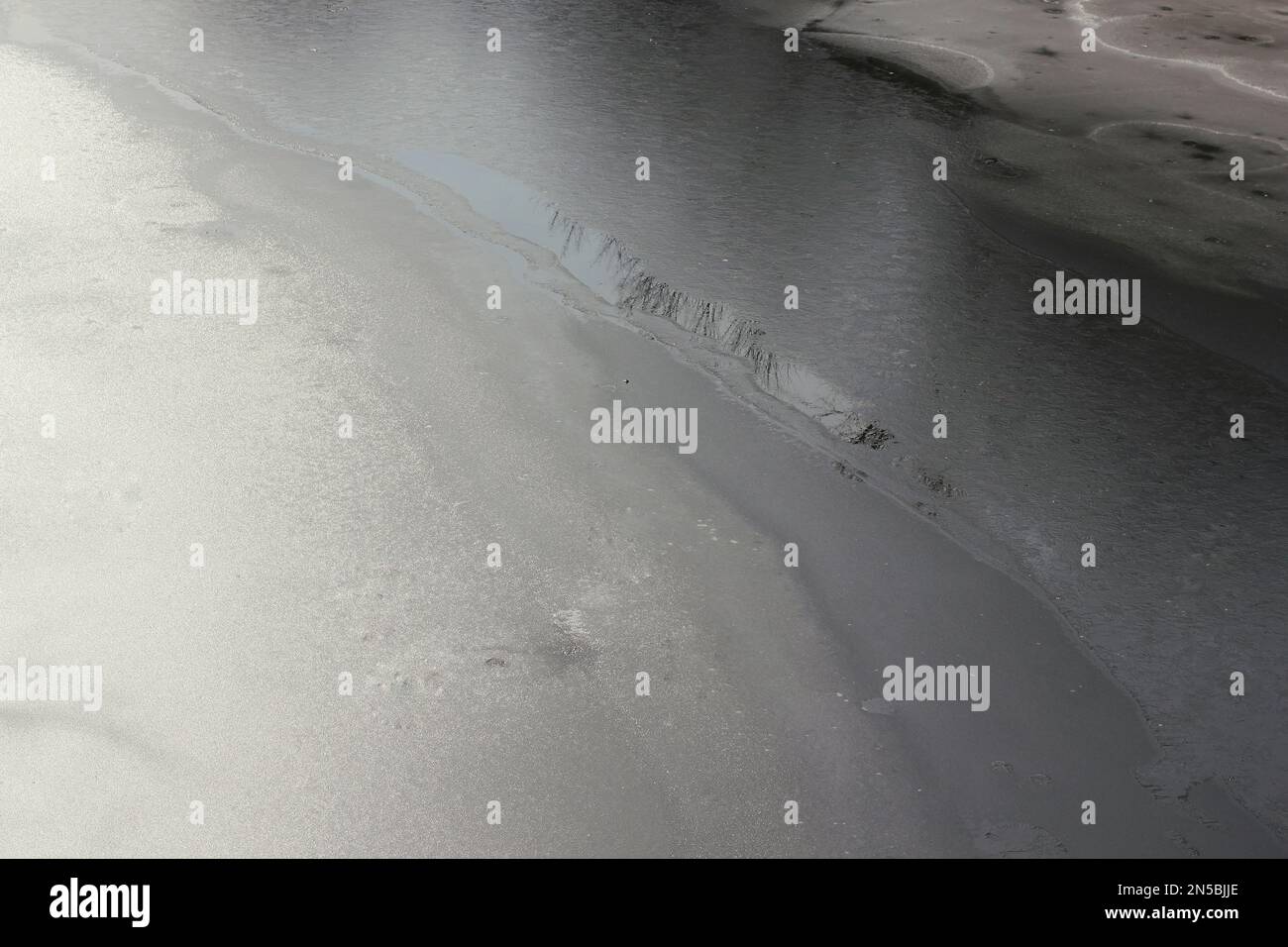 Fiume ghiacciato che si snoda attraverso la foresta selvaggia una giornata invernale fredda e gelida. Foto Stock