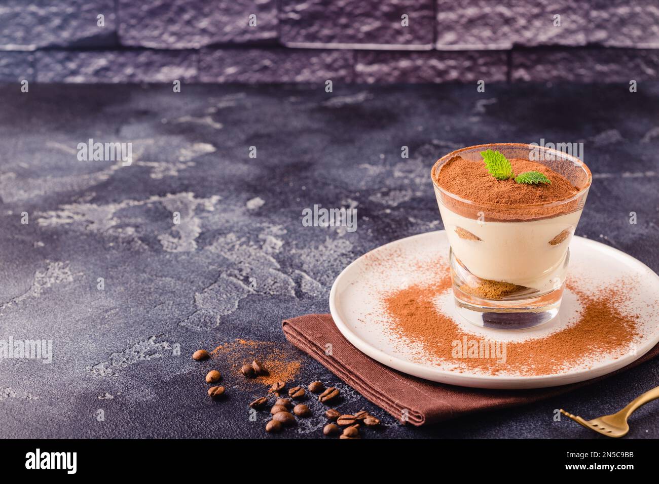 Tiramisù tradizionale dessert italiano in un bicchiere, focus selettivo Foto Stock