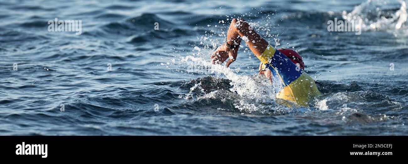 Triatleta professionista nuoto in mare aperto, triathlon maschile nuoto in tuta professionale triathlon Foto Stock
