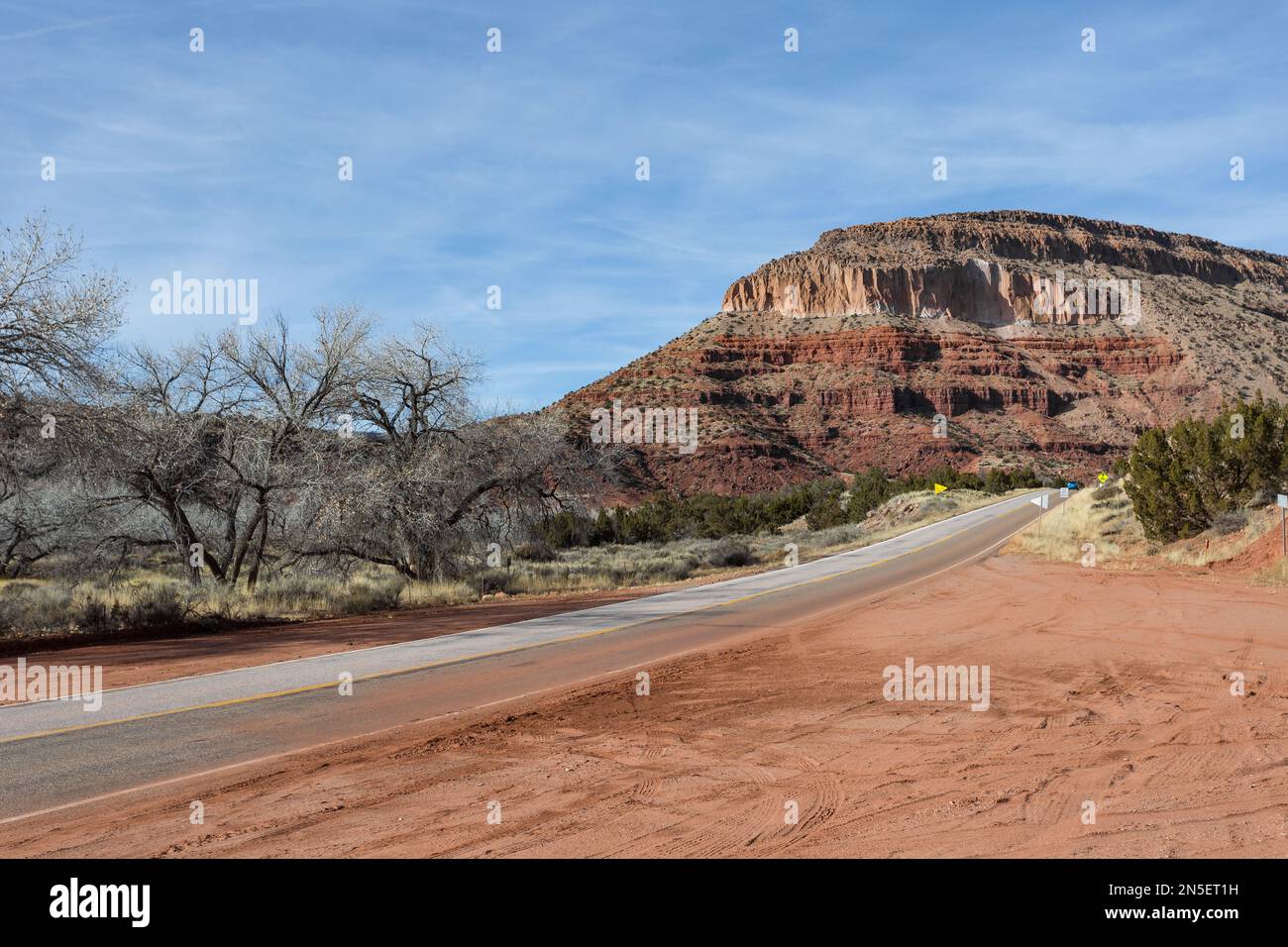 Strada che conduce alla catena montuosa nel deserto del New Mexico rurale in una giornata limpida Foto Stock
