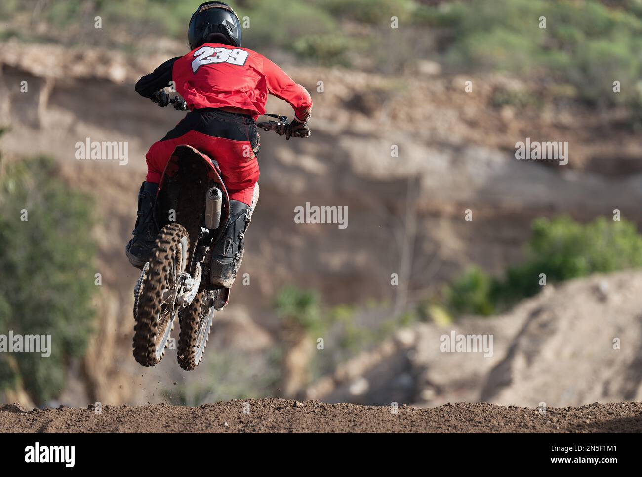 Racer ragazzo in moto partecipa alla gara di motocross, sport estremo attivo. Fotografato durante il salto Foto Stock