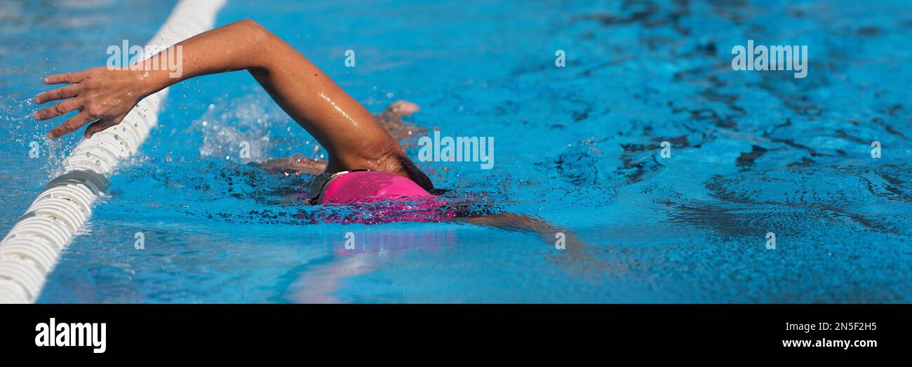 Donna nuotatrice atleta nuoto in corsie piscina facendo un giro di crawl. Gara di nuoto freestyle. Allenamento triatleta per il triathlon Foto Stock