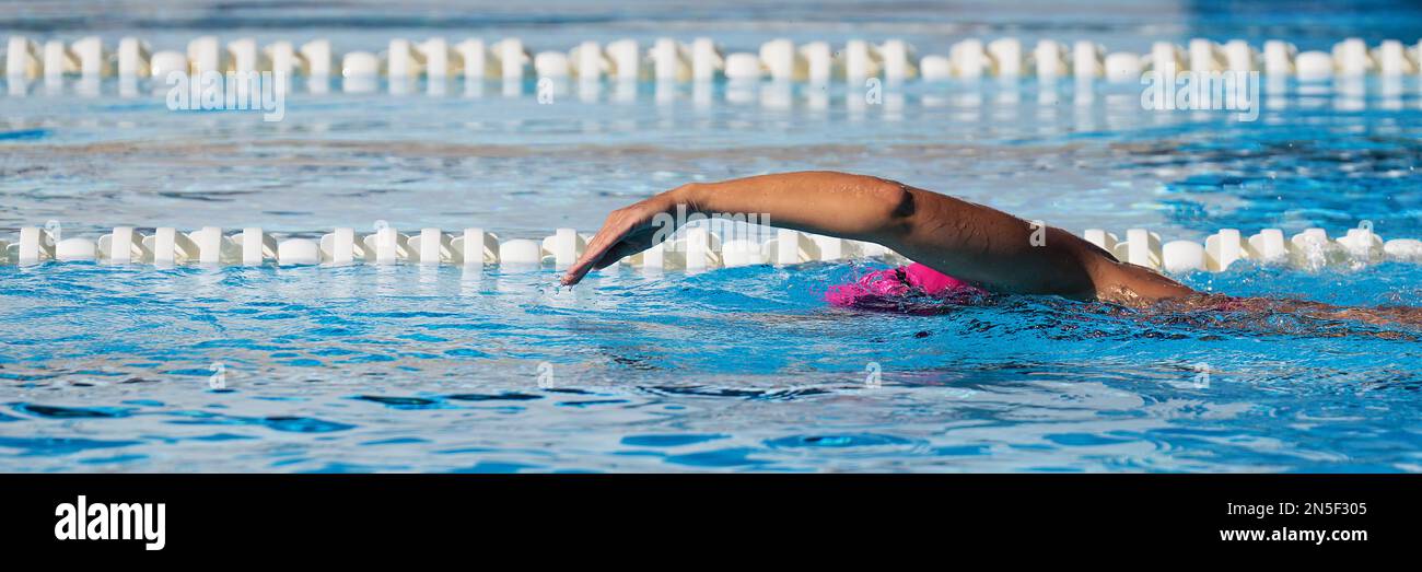 Donna nuotatrice atleta nuoto in corsie piscina facendo un giro di crawl. Gara di nuoto freestyle. Allenamento triatleta per il triathlon Foto Stock