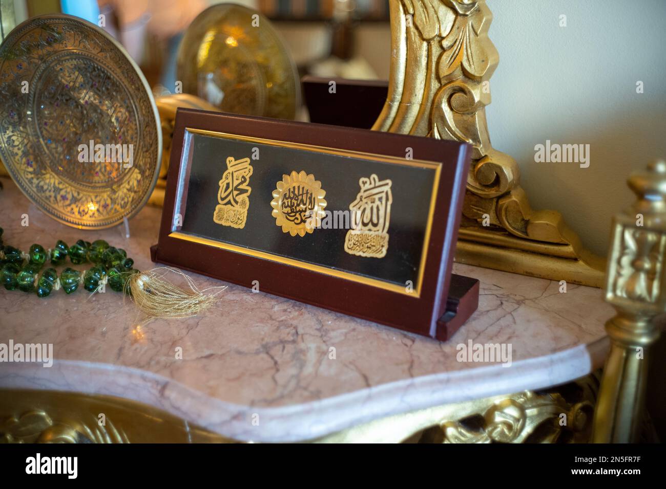 Betlemme, Cisgiordania, Palestina - 22 luglio 2022: Vestito d'oro con vari simboli arabi su un piccolo tavolo in un elegante soggiorno Foto Stock