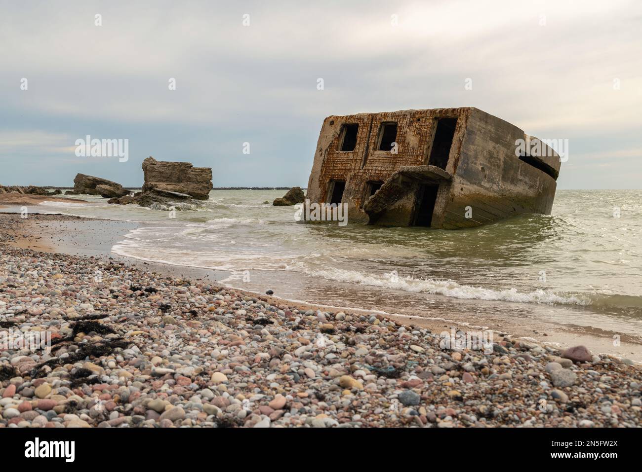 Edifici abbandonati sulla riva del mare in acqua. Rovine di guerra che si decompongono nel Mar Baltico. Ex bunkers forte a Liepaja, Lettonia. Foto Stock