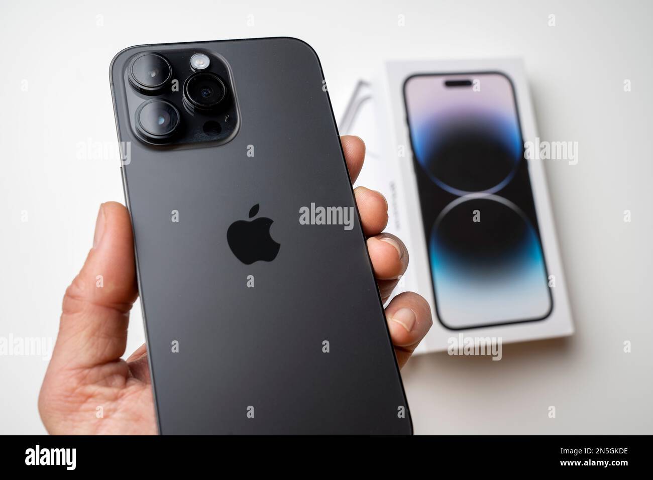Un uomo possiede l'ultimo iPhone 14 Pro Max in Space Black. L'ultimo  telefono Apple è dotato di tre fotocamere Foto stock - Alamy