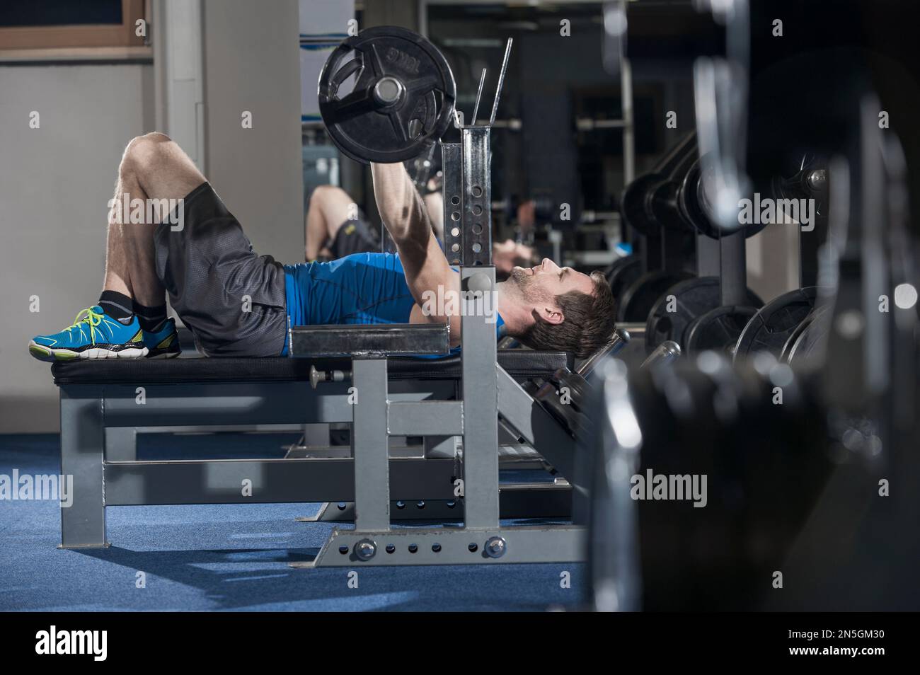 Uomo medio adulto che fa la pressa della panca nella palestra, Baviera, Germania Foto Stock