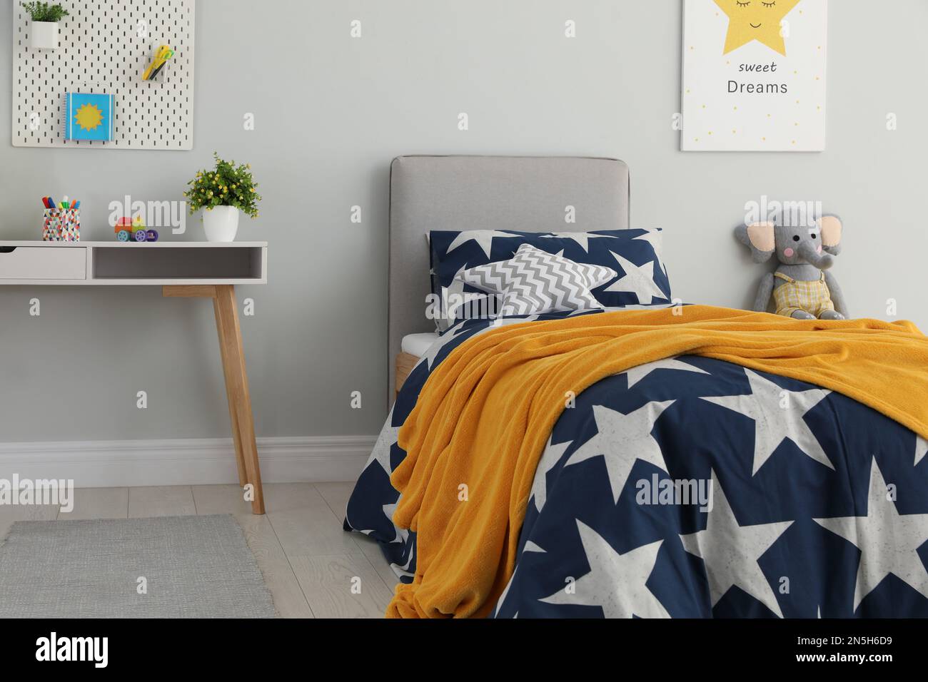 Letto con lenzuola a motivi stelle nella camera per bambini. Design degli  interni Foto stock - Alamy