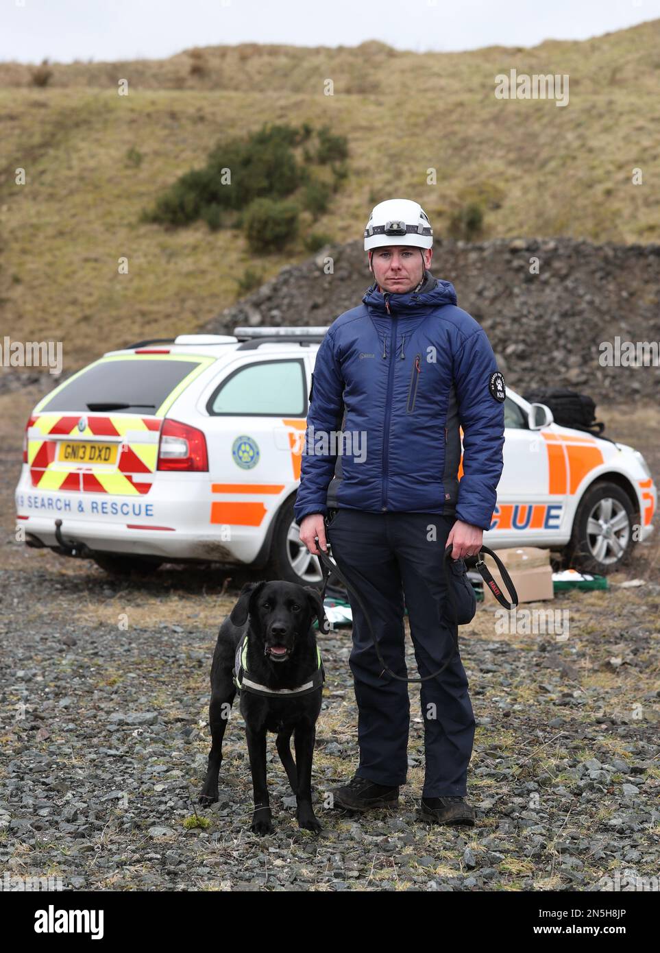 K9 Search and Rescue NI team leader, Ryan Gray con cane max alla cava di Wolf Hill, Belfast. I membri dell'associazione di beneficenza per la ricerca e il salvataggio di cani saranno in viaggio dall'Irlanda del Nord alla Turchia per aiutare gli sforzi di ricerca a seguito dei terremoti devastanti in Turchia e Siria. Data immagine: Giovedì 9 febbraio 2023. Foto Stock