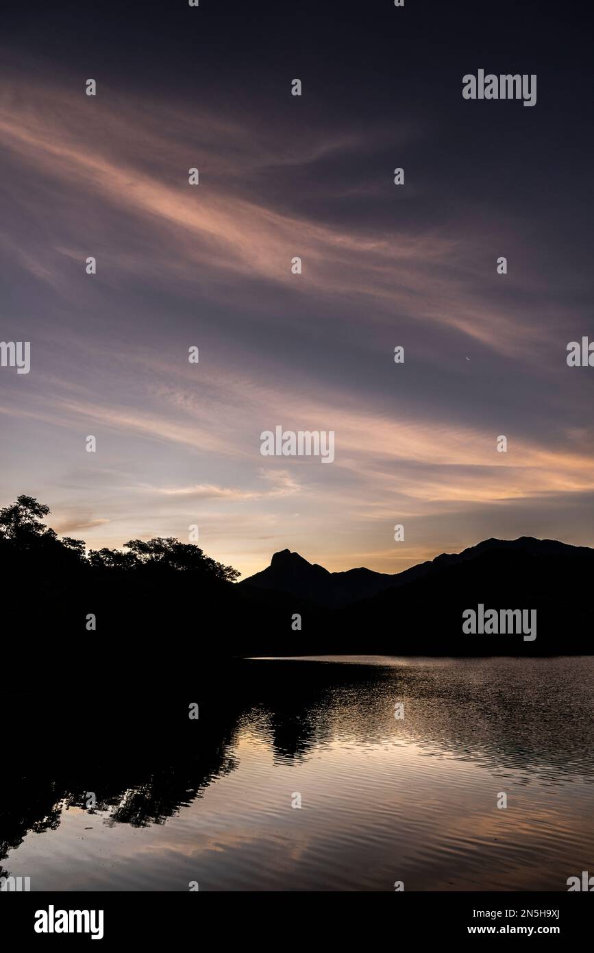 Bellissimo tramonto con nuvole arancioni sul lago della foresta pluviale Foto Stock