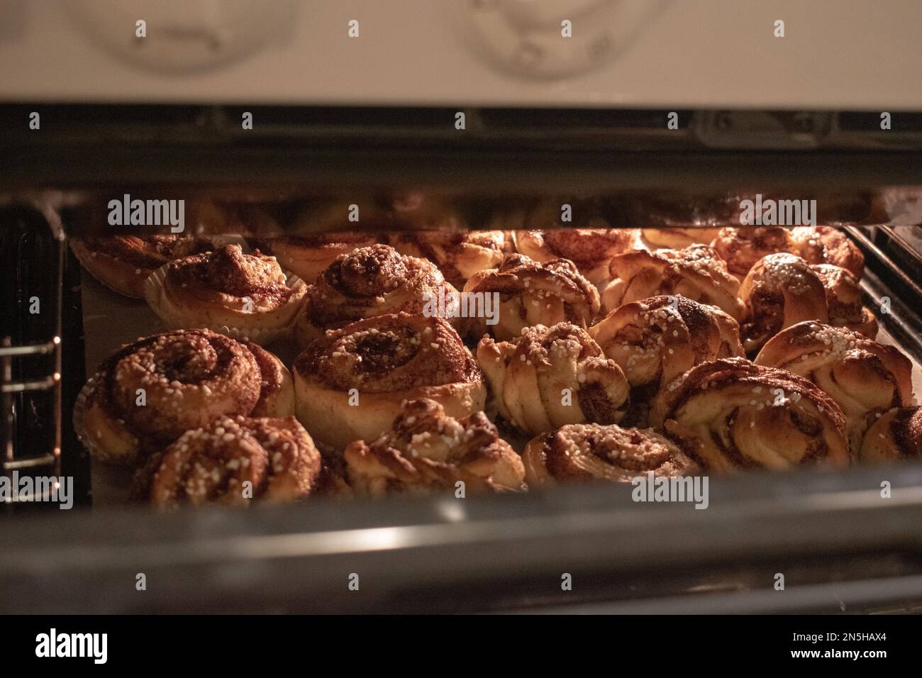 Panini alla cannella svedesi appena sfornati con zucchero perla. Kanelbullar in svedese. Foto Stock