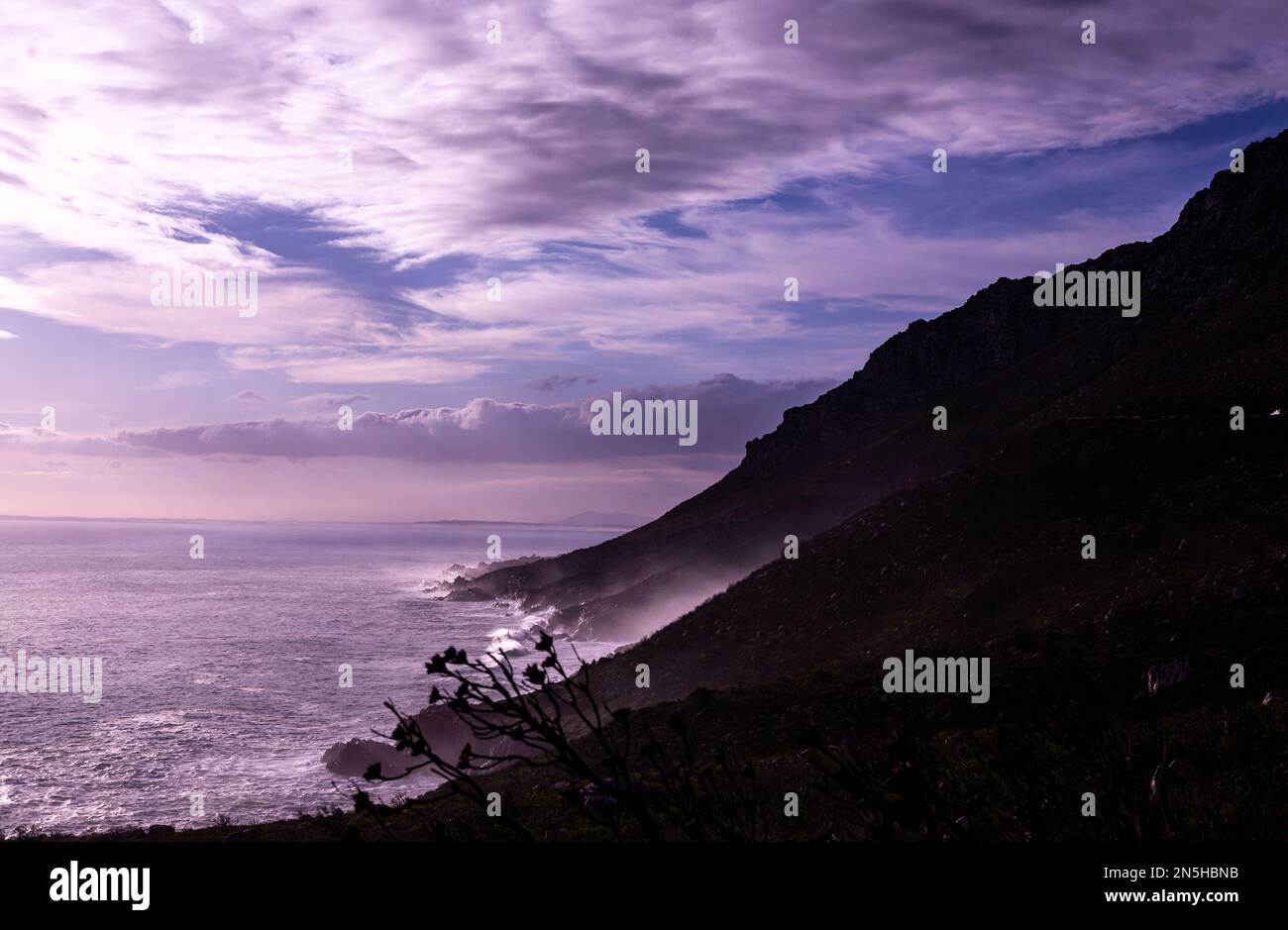 Mare scuro con la montagna e le nuvole Foto Stock