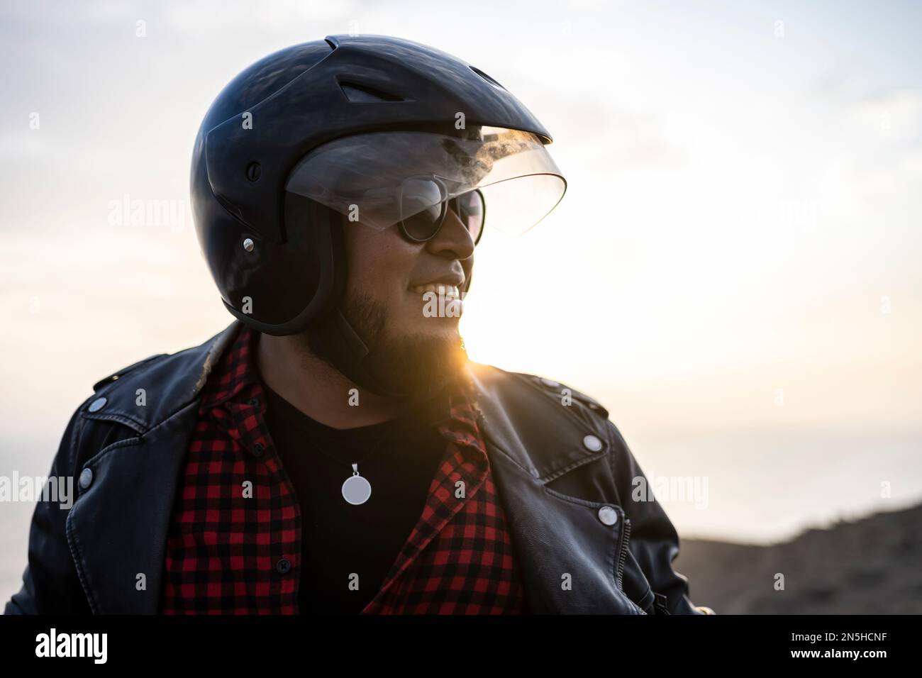 Biker bearded sorridente al tramonto. Foto Stock