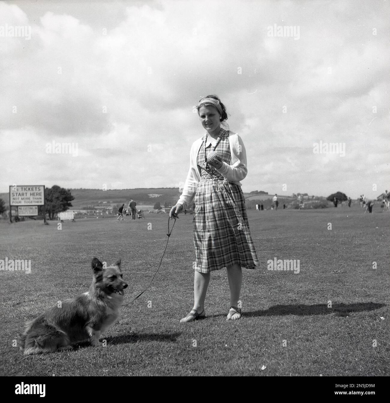 1963, storica, estiva e una giovane donna, con il suo piccolo cane sul campo da golf Browns, Isola di Wight, Inghilterra, Regno Unito, un campo e messo sul lungomare di Sandown che ha aperto nel 1932. Foto Stock