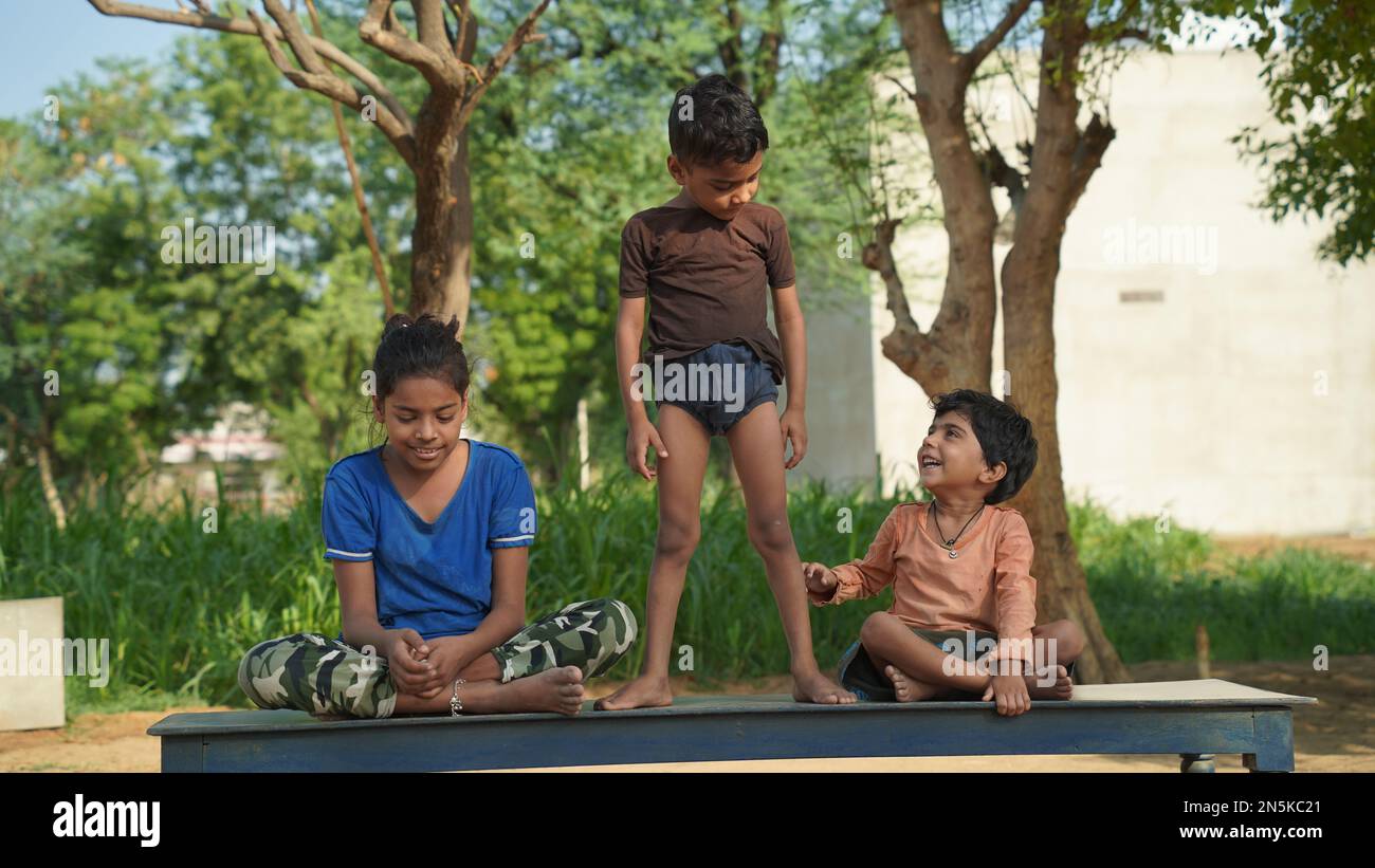 Due bambina indiana e un ragazzo che medita yoga asana su tappetino con gli occhi chiusi nel parco. Foto Stock