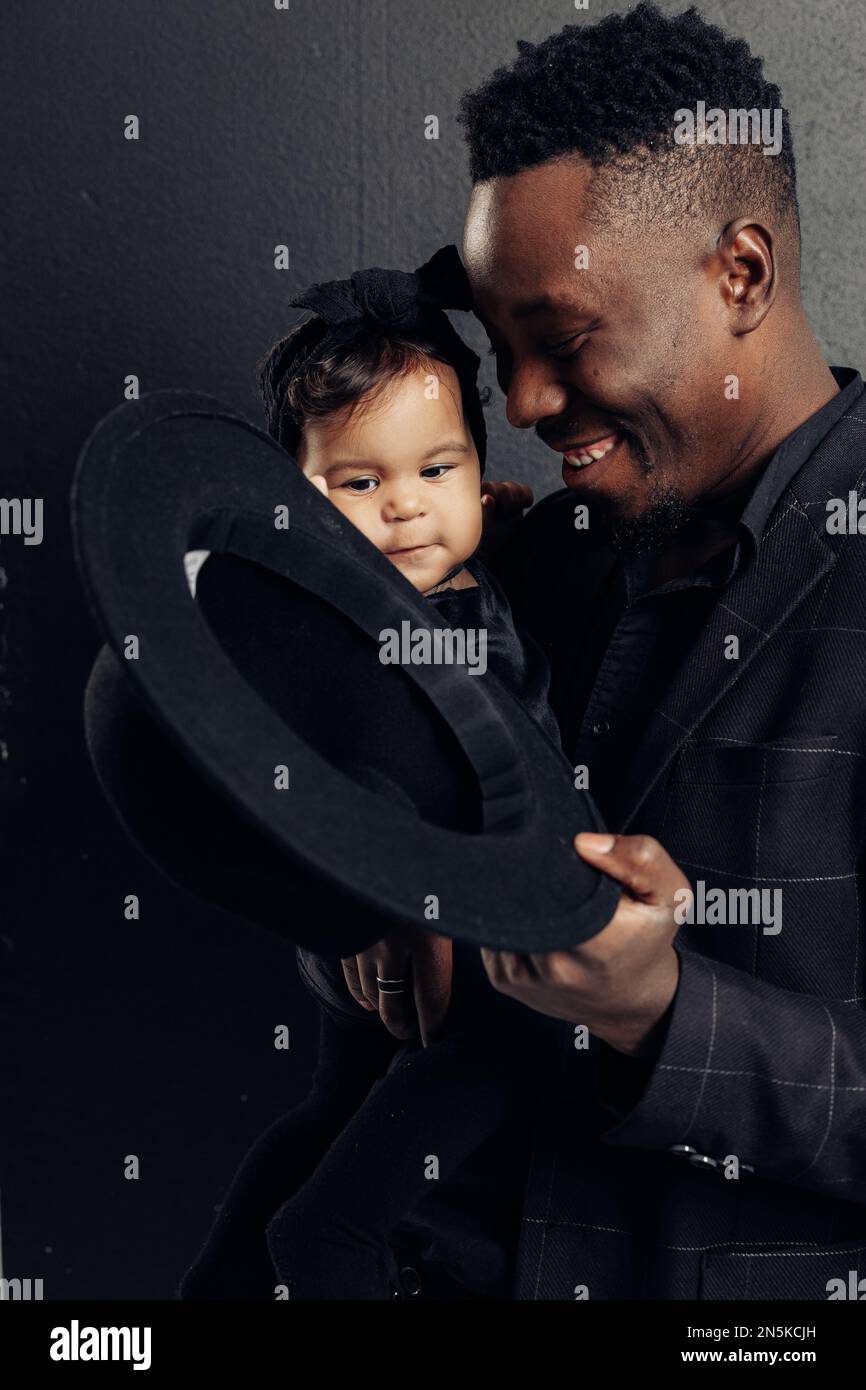 Il giovane uomo africano gioca con la figlia del bambino dal matrimonio interracial. Concetto di famiglia interrazziale e unità tra diverse razze umane. Foto Stock
