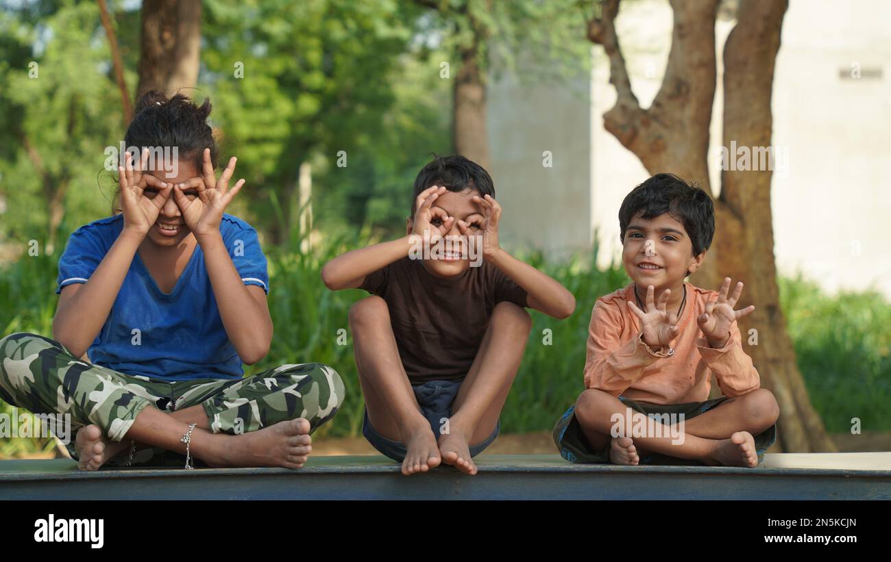 Divertenti bambini che fanno una posa yoga nel parco all'aperto. Concetto di stile di vita sano. Foto Stock
