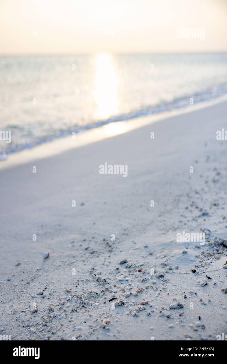 Sfondo di spiaggia di sabbia vuota al bordo delle acque guardando verso il tramonto riflessione nell'Oceano Indiano; le Maldive Asia. Concetto - futuristico Foto Stock