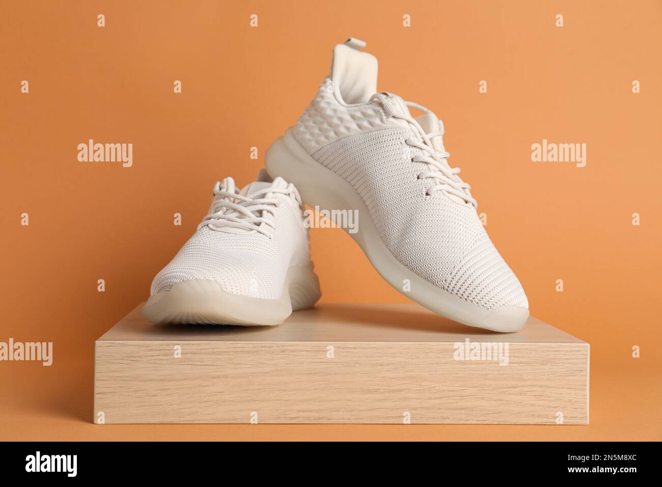 Paio di eleganti scarpe sportive su sfondo arancione Foto Stock