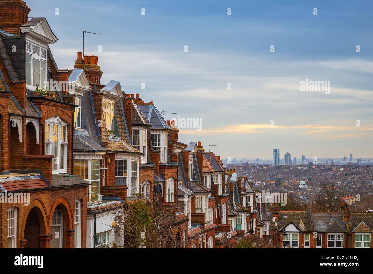 Londra, Regno Unito - tradizionali case in mattoni inglesi in una mattinata nuvolosa con Londra est sullo sfondo. Scatto panoramico da Muswell Hill Foto Stock