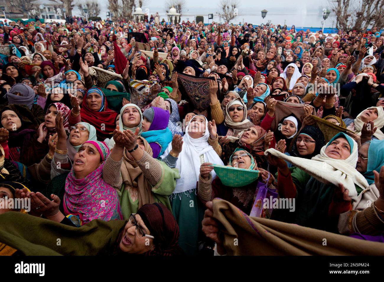 Kashmiri Muslim women raise their hands in prayer as a head priest ...