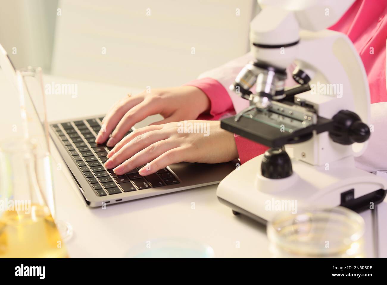 Scienziato femminile che lavora al computer portatile in laboratorio di ricerca. Foto Stock