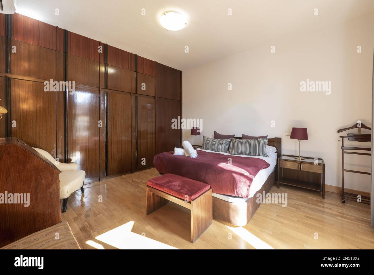 Camera da letto con letto matrimoniale e divano-letto pieghevole, armadio a  muro in legno e pavimento in quercia Foto stock - Alamy